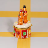 Side view of the Gingerbread Couple Trinket Box showing the two figures and round patterned base