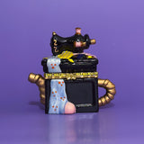 Front view of ceramic sewing machine trinket box with gold trim and pastel fabric accents.