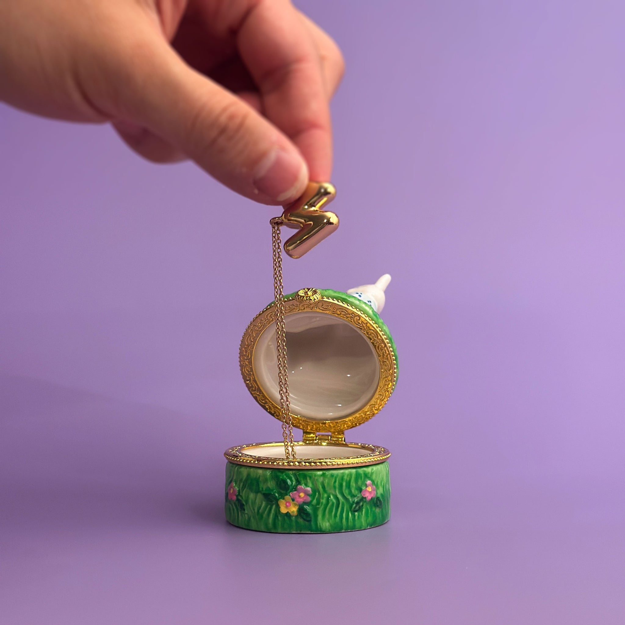 person opening ceramic bunny trinket box to show jewelry storage inside