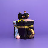 Side view of hand-painted ceramic sewing machine trinket box with draped fabric details.